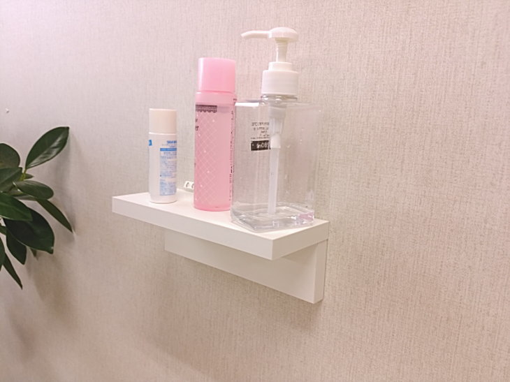洗面所の壁に取り付けた棚に化粧水やコンタクト洗浄液を載せる